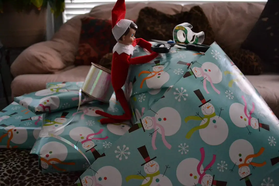 boy elf wrapping christmas presents chintz wrapping presents
