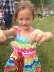 little girl holding crawfish