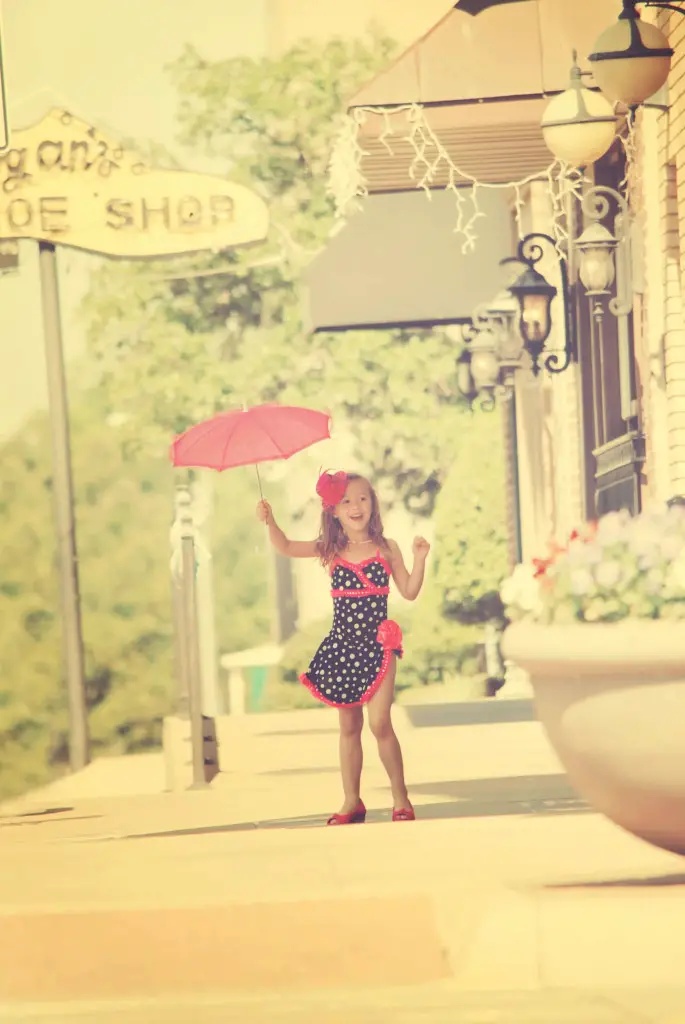 Small girl holding a umbrella in dance costume