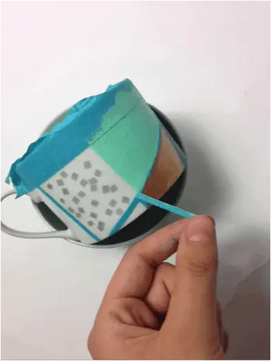 Peeling tape off mug