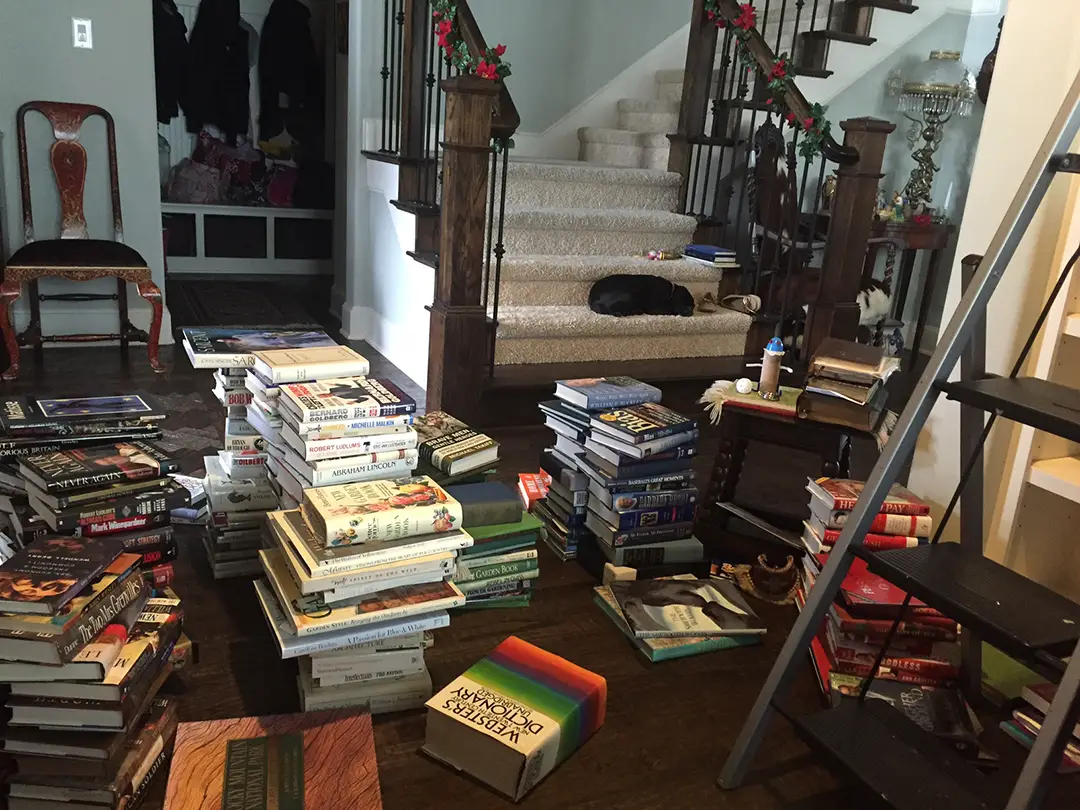books out of the bookcase preparing to color order books for a rainbow book shelf