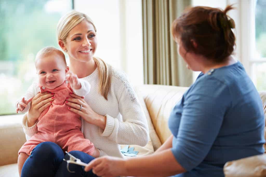 Health Visitor Talking To Mother With Young Baby