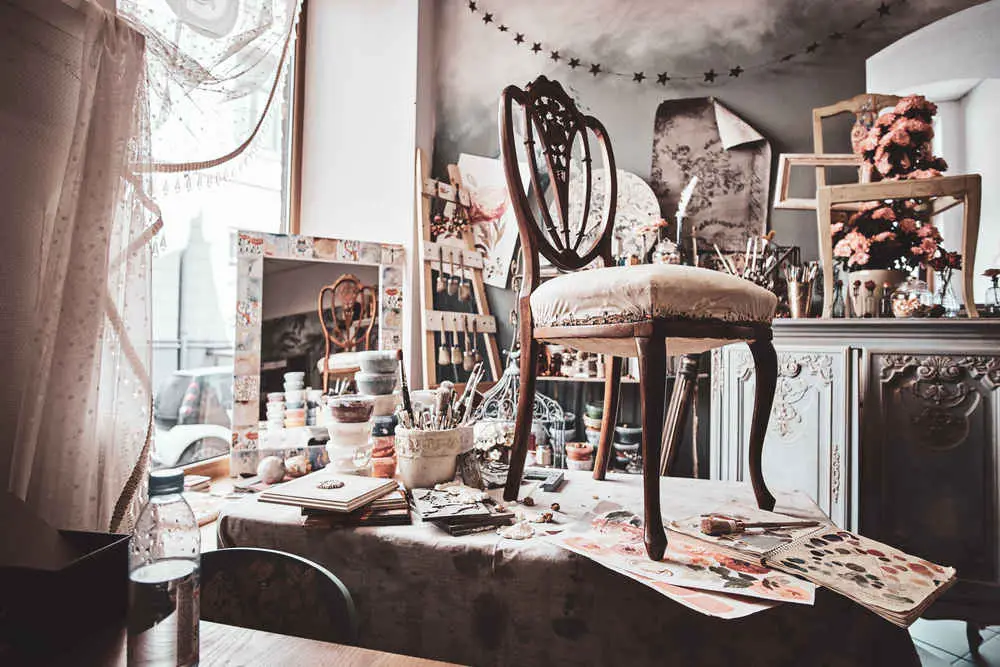 Photo of artist's pretty soiled workshop with chair ready for restouration on the table. craft room chaos